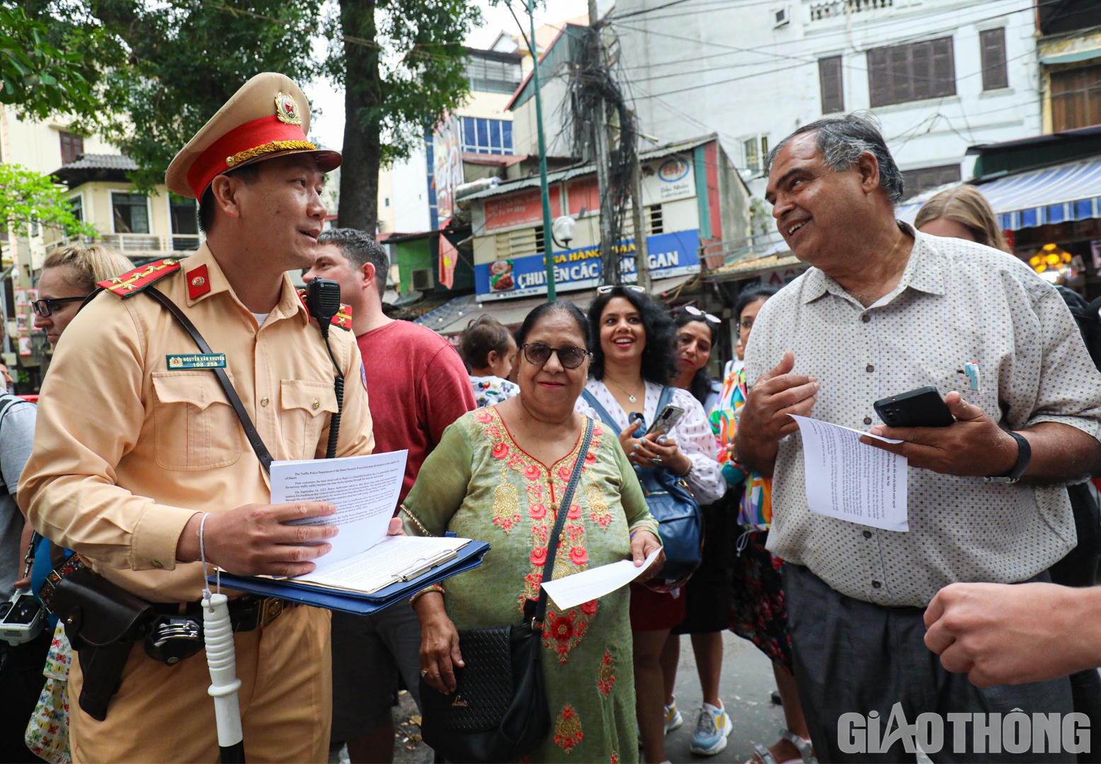 Nhận được tờ rơi song ngữ, nhiều du kh&aacute;ch vui vẻ chấp h&agrave;nh hướng dẫn của lực lượng chức năng, kh&ocirc;ng bước qua h&agrave;ng r&agrave;o an ninh để chụp ảnh lưu niệm.