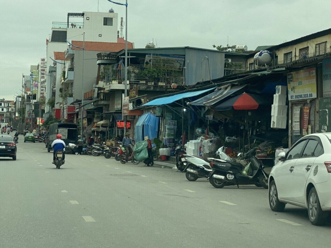 Khu vực qua cổng chợ Giếng Đáy, hàng hóa, biển quảng cáo… được người dân tận dụng để hết ra vỉa hè.