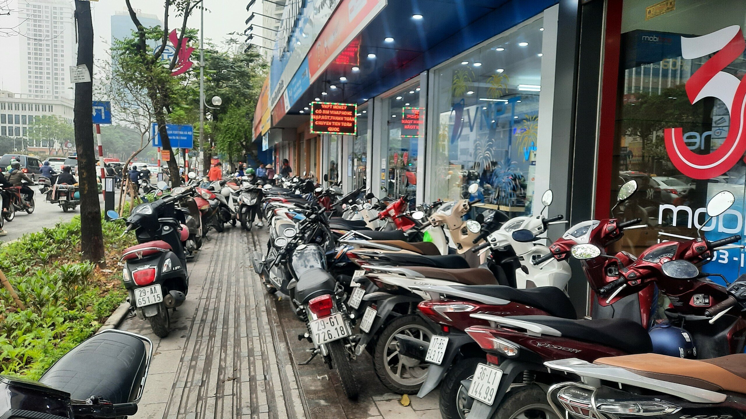 Lượng khách đông đến mức vỉa hè trước cửa hàng chật kín phương tiện xe máy.