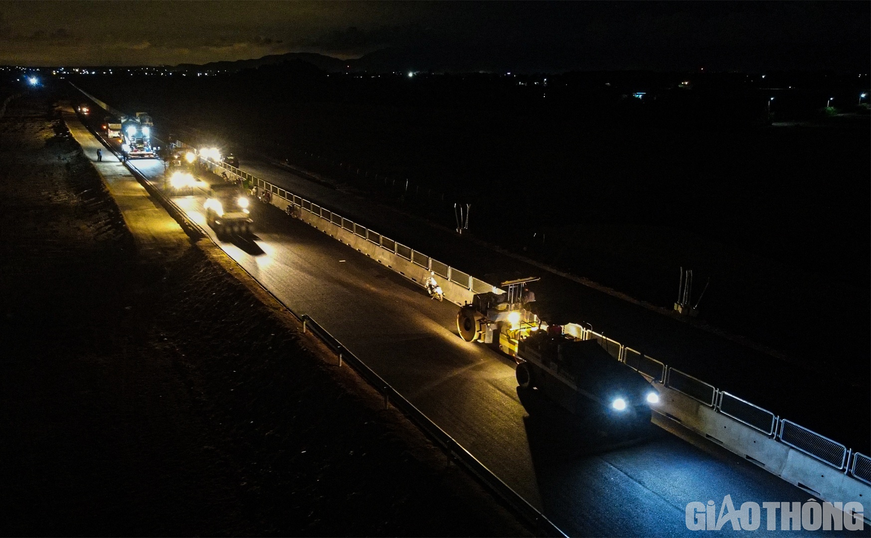 Thường trực trên công địa gói thầu XL4 còn là những đêm “chong đèn” rải thảm với những người công nhân áo ướt đẫm mồ hôi. Mỗi chuyến bê tông nhựa được đưa vào máy rải, chẳng cần khẩu trang hay đồ bảo hộ cầu kỳ, họ lại lao vào khớp nối với dây chuyền, đảm bảo những lớp thảm được trải sẽ đạt chất lượng tốt nhất
