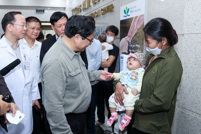 Thủ tướng nắm tay, thăm hỏi một cháu bé đang điều trị ở Bệnh viện Nhi.