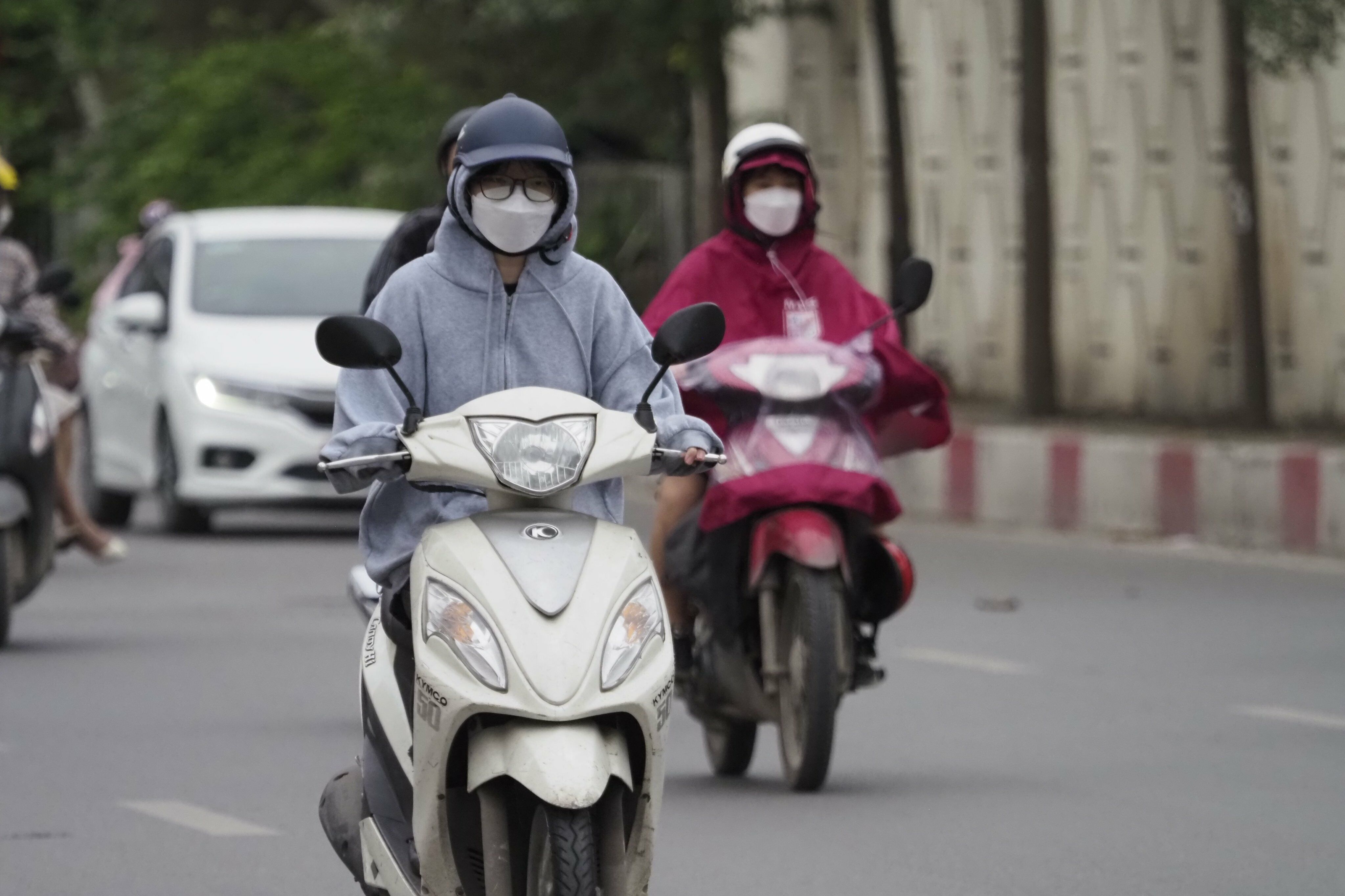 Nhiều người chủ quan không mặc áo khoác phải dừng xe mặc tạm áo mưa.