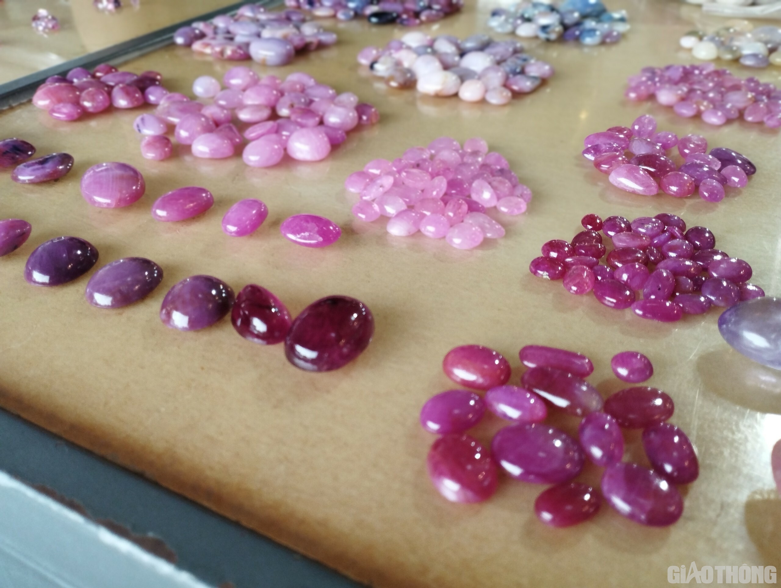 Những viên đá quý có giá trị từ vài trăm nghìn, thậm chí hàng trăm triệu đồng được bày bán trên mặt bàn gỗ.