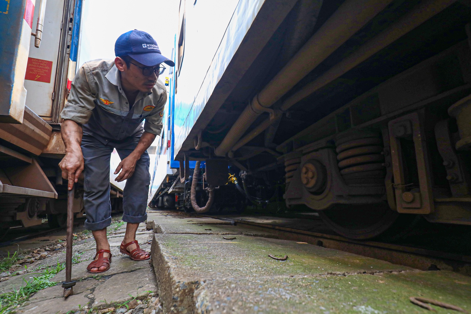 Công nhân khám chữa toa xe kiểm tra bộ phận chạy trước khi tàu xuất phát