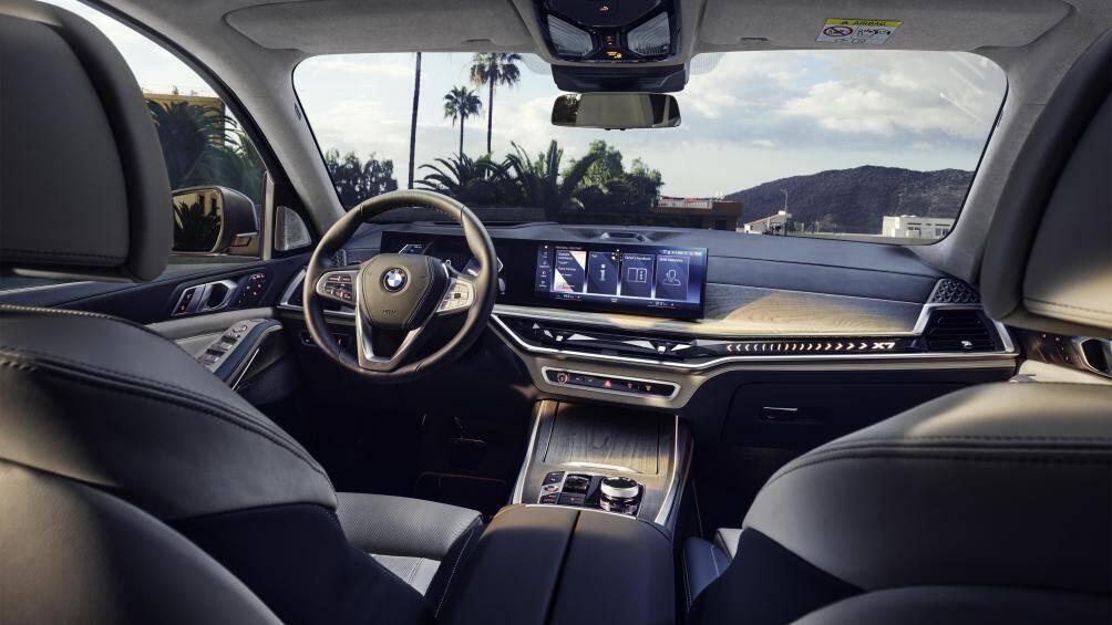 Bệ lái trên BMW X7 xDrive40i Pure Excellence được ốp gỗ Individual Ash Grain Silver Grey cao cấp kết hợp với hệ thống điều hoà tự động 5 vùng độc lập, đèn viền nội thất Ambient Light