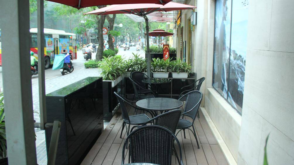 Mặt sàn được xếp bằng những tấm gỗ, bàn ghế được để đơn giản nhưng view khá thu hút do nằm ở giữa ngã tư.