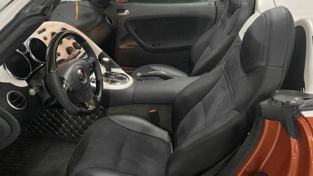 Ngoài phần ghế ngồi và một nửa bảng điều khiển trung tâm, chiếc Pontiac Solstice tại Việt Nam còn được bọc da và nhựa màu tối