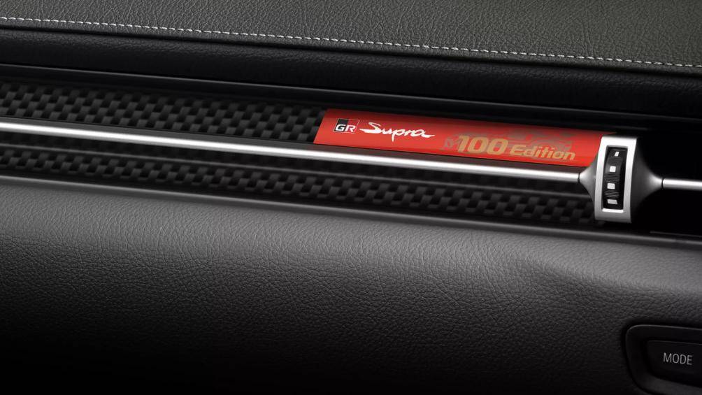 Điểm nhấn của ghế là đường chỉ màu trắng kết hợp cam. Đặc biệt tại ghế phụ có bảng carbon ghi "GR Supra 100 Editions"