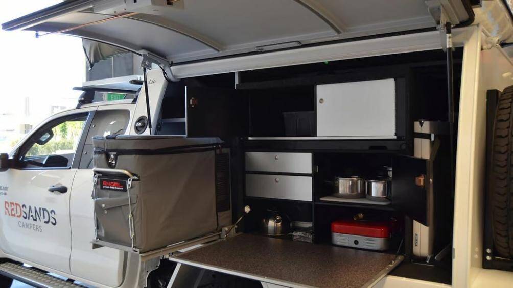 Thùng sau xe Hilux được cải tạo thành không gian sinh hoạt chung với một loạt các trang bị tiện nghi như tủ lạnh, bể nước, bếp ga