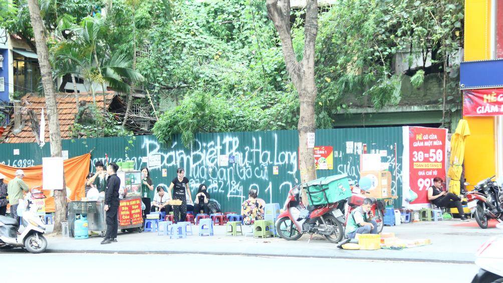 Sau khi Hà Nội triển khai cao điểm "giành lại vỉa hè cho người đi bộ", những ngày trung tuần tháng 5, PV Báo Giao thông ghi nhận, nhiều vỉa hè, lòng đường ở các tuyến phố ở Hà Nội vẫn bị chiếm dụng làm nơi kinh doanh, buôn bán, trông giữ xe... Ảnh: Quán trà đá, bánh mì bao trọn vỉa hè trên đường Thái Hà.