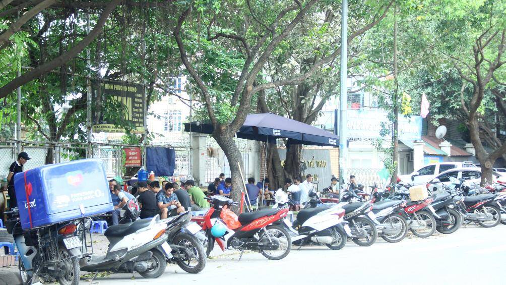 Tại tuyến đường Tú Mỡ, quận Cầu Giấy, hàng loạt quán trà đá ngang nhiên bày bàn ghế, khách ngồi kín trên vỉa hè. Dưới lòng đường, xe máy để la liệt, lộn xộn gây mất ATGT.