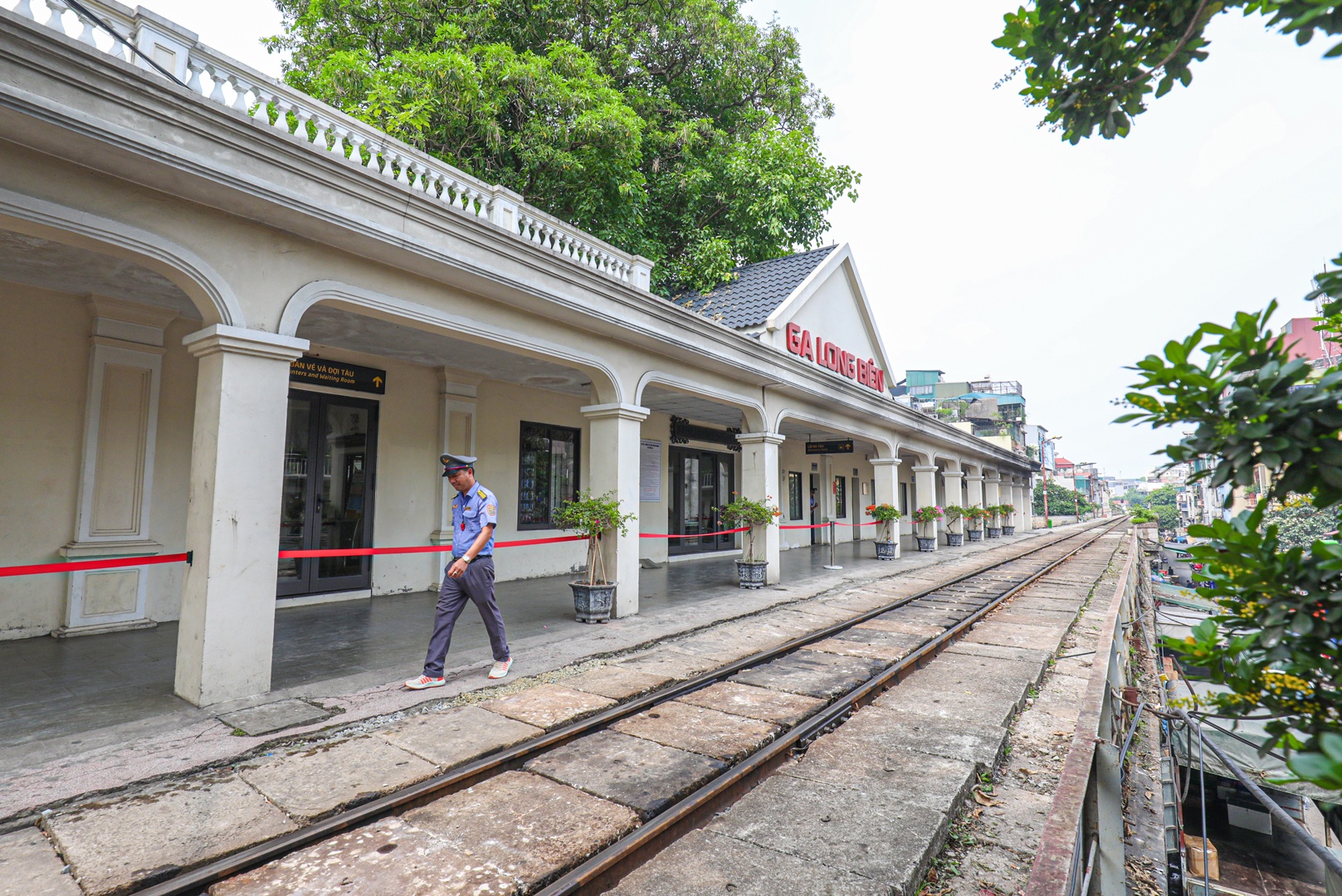 Tàu chạy, trả lại khung cảnh yên tĩnh cho khu ga Long Biên. Phía nhà ga chính, đường sắt chăng dây ngăn cách mềm suốt dọc hành lang ngăn không để hành khách từ phòng đợi ra khu vực đường sắt. Khách có thể đứng từ khu vực phòng đợi Hỏa xa cafe để chụp ảnh check-in sang.