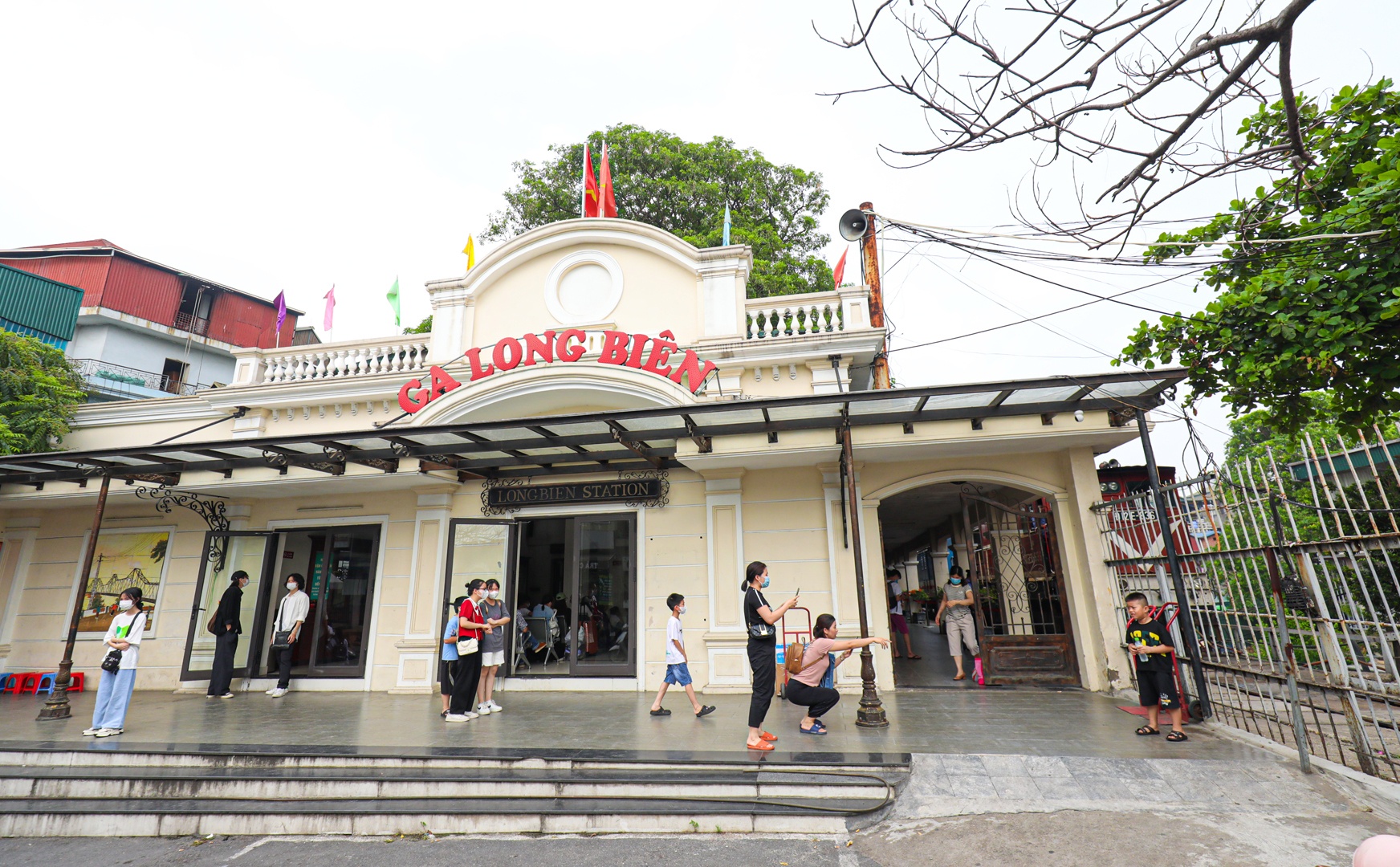 Để đến phòng đợi tàu mới, khách có thể đi từ phía cổng chính ga Long Biên. Tại đây, khách có thể chụp ảnh check-in nhà ga đã được cải tạo theo phong cách kiến trúc thời Pháp thuộc. Khánh thành và hoạt động từ năm 1902, ga Long Biên còn có tên gọi là ga Đầu Cầu do chỉ nằm cách cầu Long Biên vài mét. Toàn bộ khu nhà chính của ga được đặt trên các vòm đá hộc của cầu dẫn tàu hỏa chạy dọc phố Gầm Cầu. Nhà ga thực sự là một điểm dừng chân đặc sắc trong hành trình khám phá Hà Nội.