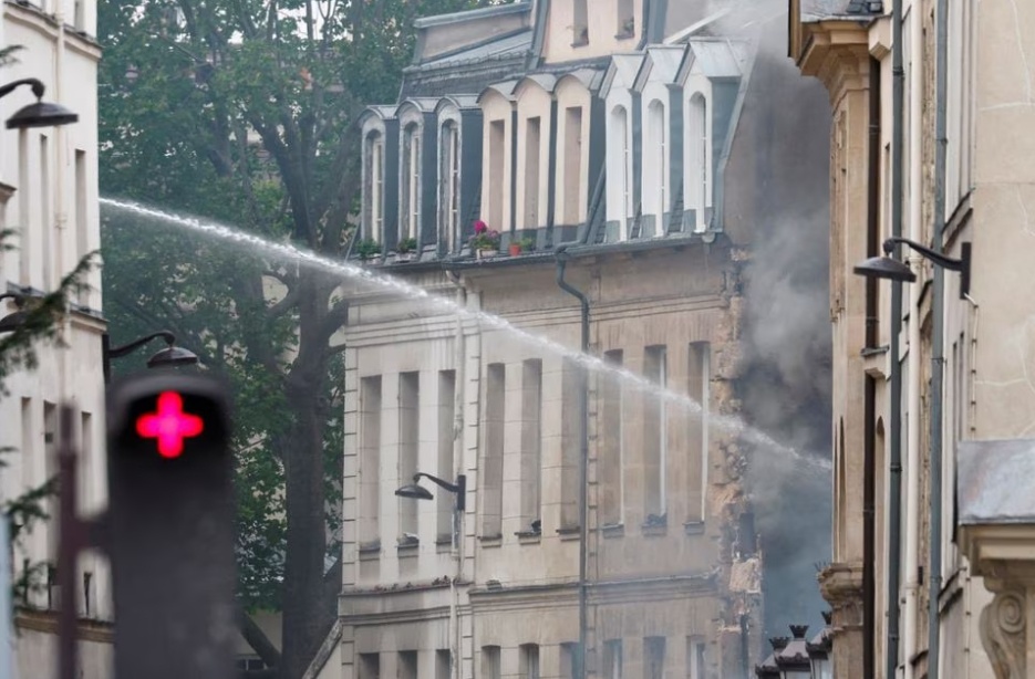 Vụ nổ phá hủy mặt ngoài tòa nhà nơi đặt trụ sở Học viện Mỹ tại Paris - trường thiết kế có đông đảo sinh viên nước ngoài theo học. Một vài tòa nhà gần đó đã được sơ tán. Khoảng 2 giờ sau khi vụ nổ xảy ra, đội phản ứng nhanh vẫn đang hỗ trợ những người bị sốc. Một phụ nữ ngất xỉu giữa phố. (Ảnh: Reuters)
