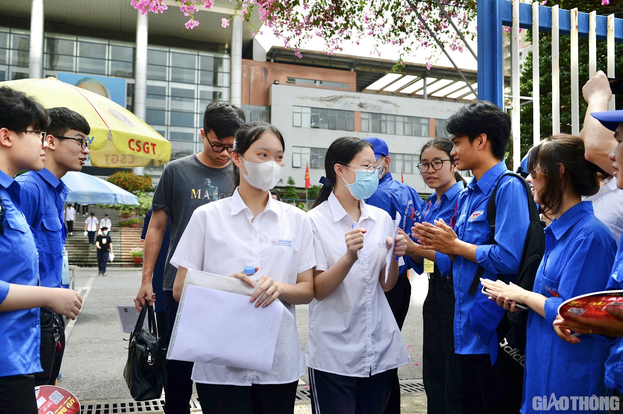Các thí sinh rời khỏi phòng thi trong tràng pháo tay động viên của các tình nguyện viên