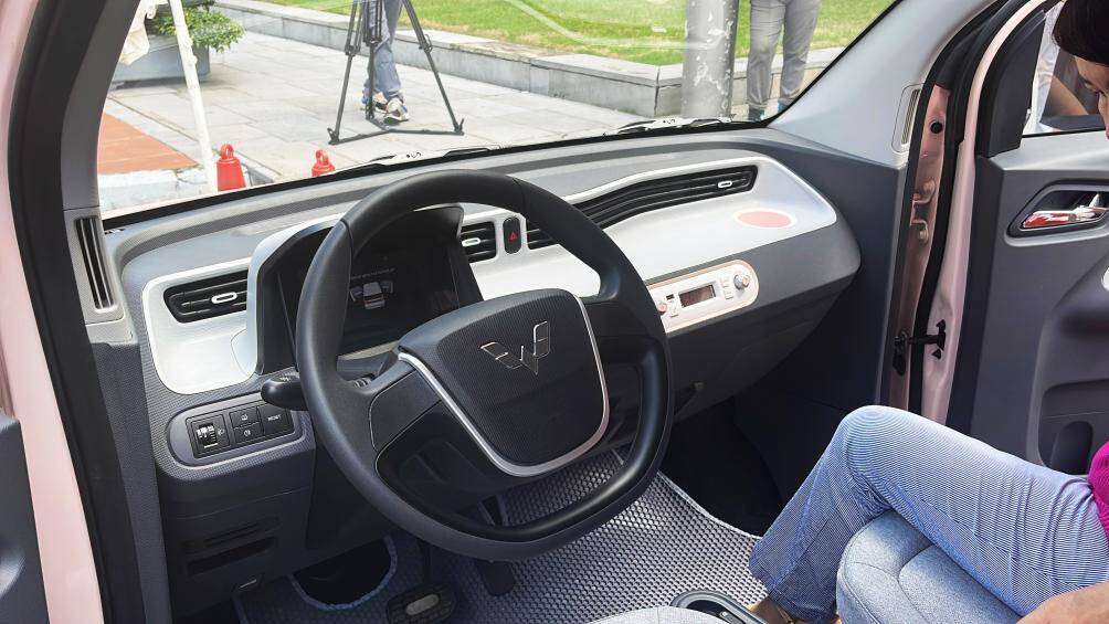 Không gian nội thất Wuling Hongguang Mini EV tương đối đơn giản khi chỉ có một màn hình LCD 7 inch duy nhất để hiển thị thông tin lẫn camera lùi. Trang bị ở mức tối thiểu với điều hoà, kết nối bluetooth và âm thanh 1 - 2 loa tùy từng phiên bản