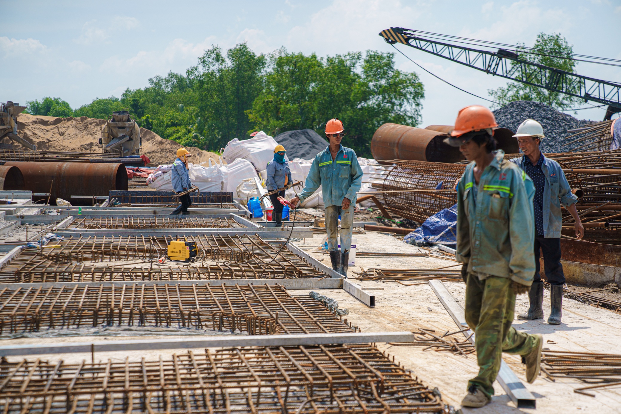 Ngoài các hạng mục thi công giữa sông, phía trên bờ, những đầu việc khác đang được thực hiện song song.