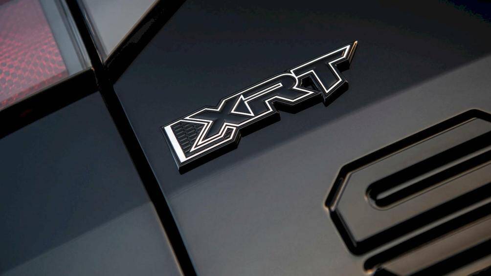 Bên cạnh đó là nắp chụp trục bánh xe màu cam, tay nắm cửa/ốp gương chiếu hậu màu đen và logo XRT mới trên cửa thùng hàng.