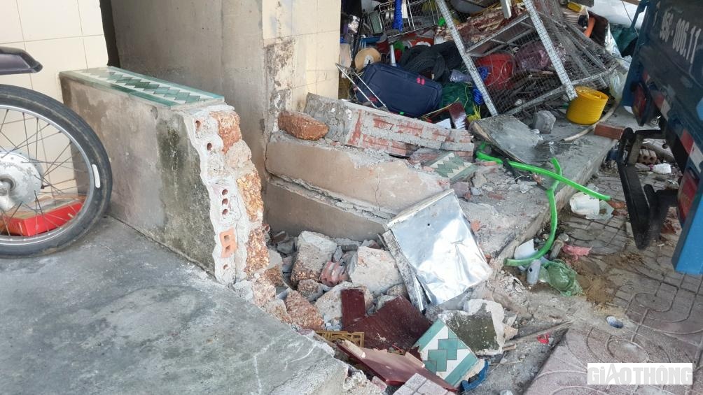 Cú tông mạnh xe tải khiến bờ tường nhà của hai hộ dân bị bể vụn.