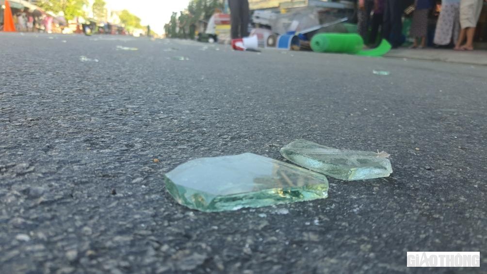 Hàng trăm mảnh kính văng tung tóe khắp nơi trên nền đường QL1 và cả các nhà dân gần đó.