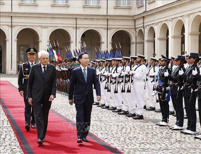 Tại nơi đỗ xe trước thảm đỏ, Tổng thống Italy Sergio Mattarella và con gái tới đón, bắt tay, nhiệt liệt chào mừng Chủ tịch nước Võ Văn Thưởng và phu nhân. Trong tiếng nhạc chào mừng, Tổng thống Italy mời Chủ tịch nước Võ Văn Thưởng cùng bước đến vị trí danh dự. Quân nhạc cử Quốc thiều hai nước (Ảnh: Báo quốc tế).