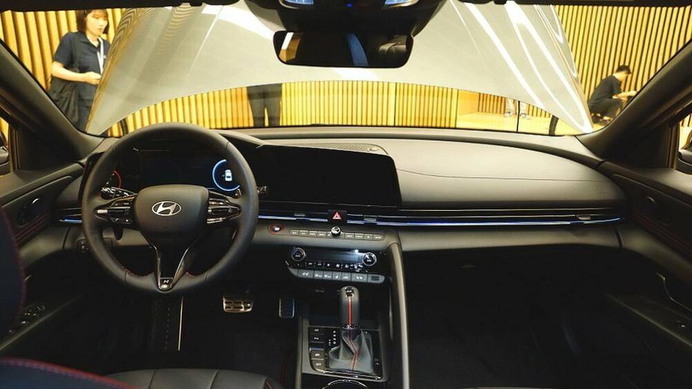 Bên trong xe, Hyundai Elantra N Line 2024 tạo sự khác biệt với bản thường bằng vô lăng ba chấu và cần số thể thao hơn, đi kèm logo "N".