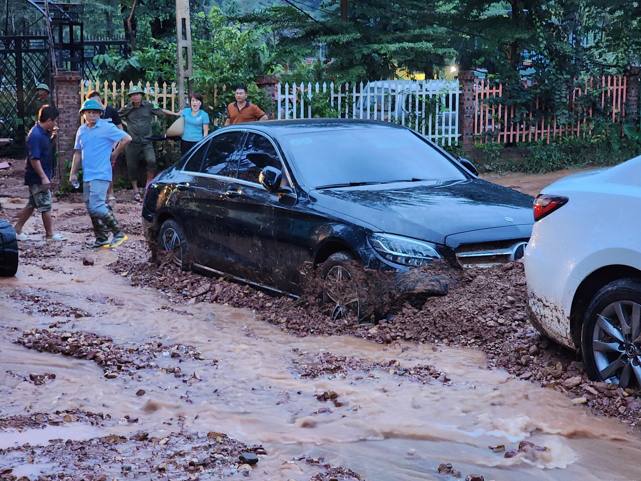 Trưa 4/8, sau những cơn mưa lớn, đã xảy ra sạt lở ở xóm Ban Tiện, thôn Phú Ninh, xã Minh Phú, huyện Sóc Sơn, TP Hà Nội khiến 13 ô tô bị đất đá bủa vây, mắc kẹt hơn nửa ngày mới có thể giải cứu.