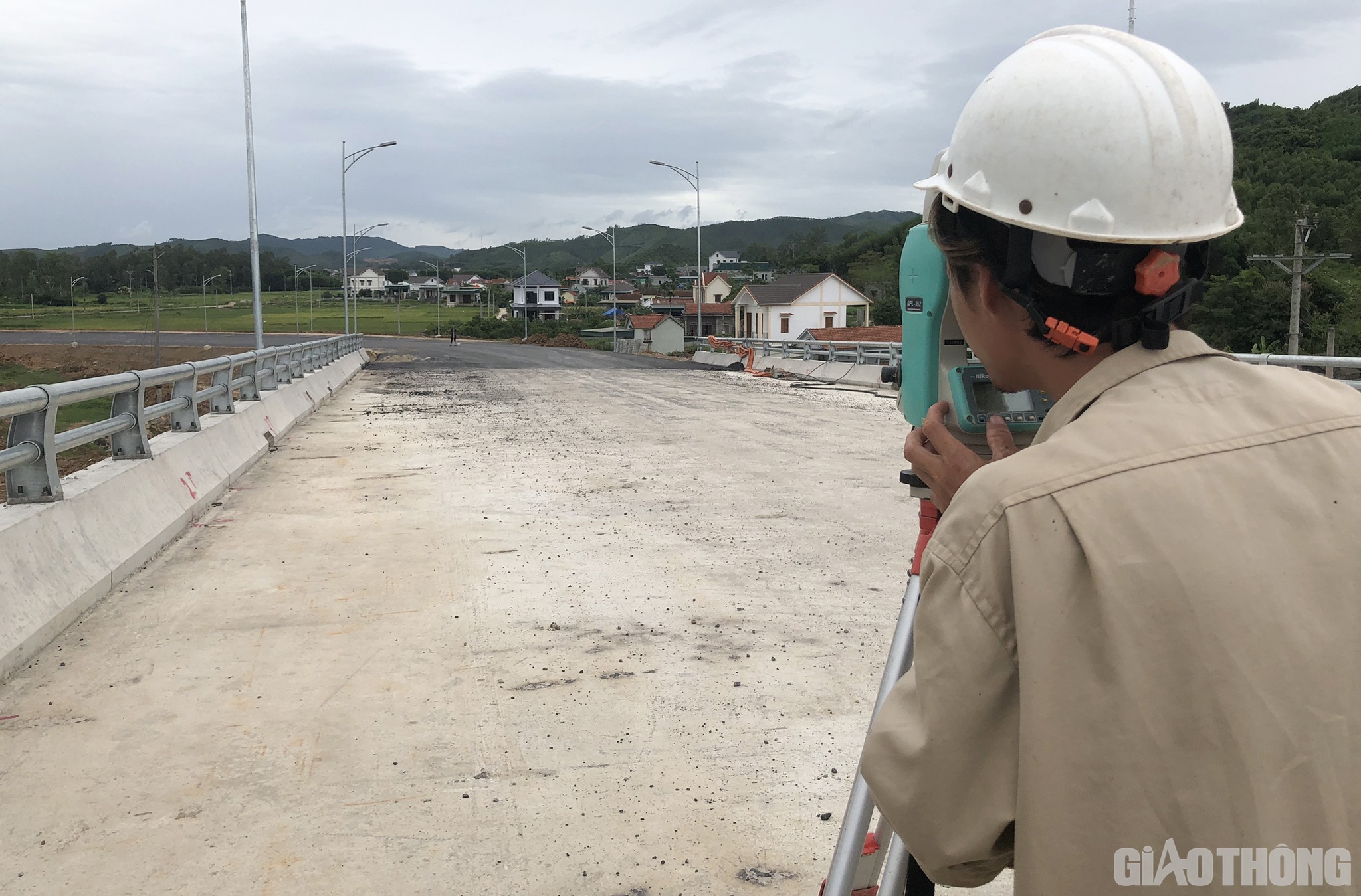 Kỹ sư trắc địa Phạm Văn Vinh, Công ty Hoà Hiệp đang xác định tim đường dẫn nút giao lên xuống trước khi thảm lớp cuối cùng của phần đường dẫn.