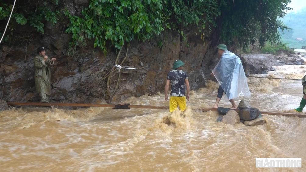 Để đi qua dòng nước chảy siết, người dân phải bám dây, đi cầu tạm.