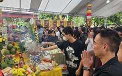 Người dân đội mưa đến chùa để thắp hương cho các nạn nhân vụ cháy chung cư mini