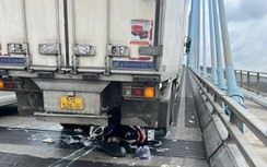 Xe máy lọt gầm xe tải giữa cầu Mỹ Thuận, 2 người nguy kịch
