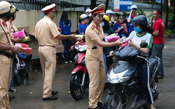 Cảnh sát giao thông "xuống đường" tặng nước, áo mưa cho sĩ tử TP.HCM