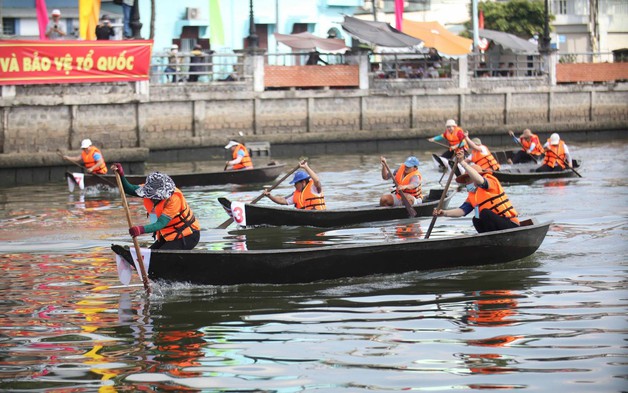 Người dân khản giọng cổ vũ các đội đua xuồng ba lá bên bờ kênh Bảo Định, Long An