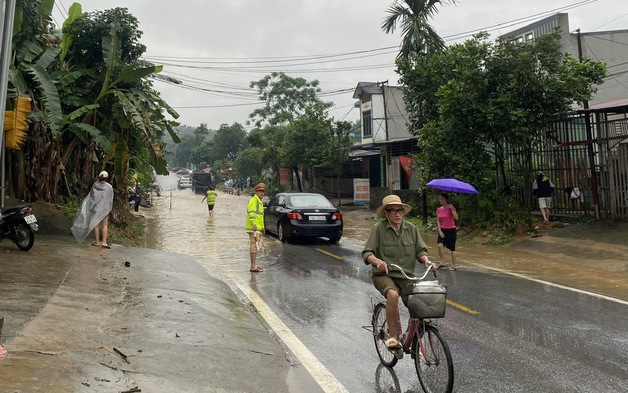 Cảnh sát giao thông Yên Bái đội mưa giúp người dân qua vùng ngập nước an toàn