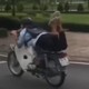 Nam thanh niên nằm trên yên điều khiển xe máy